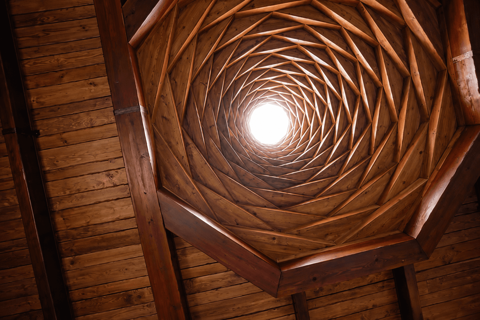 Spiralling wooden ceiling rising to a skylight