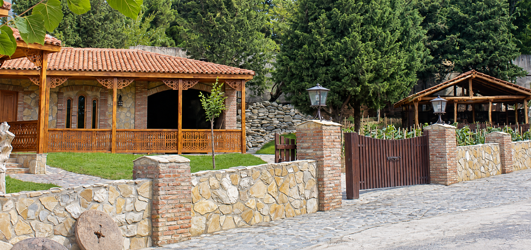 A wooden pavilion behind the stone garden wall